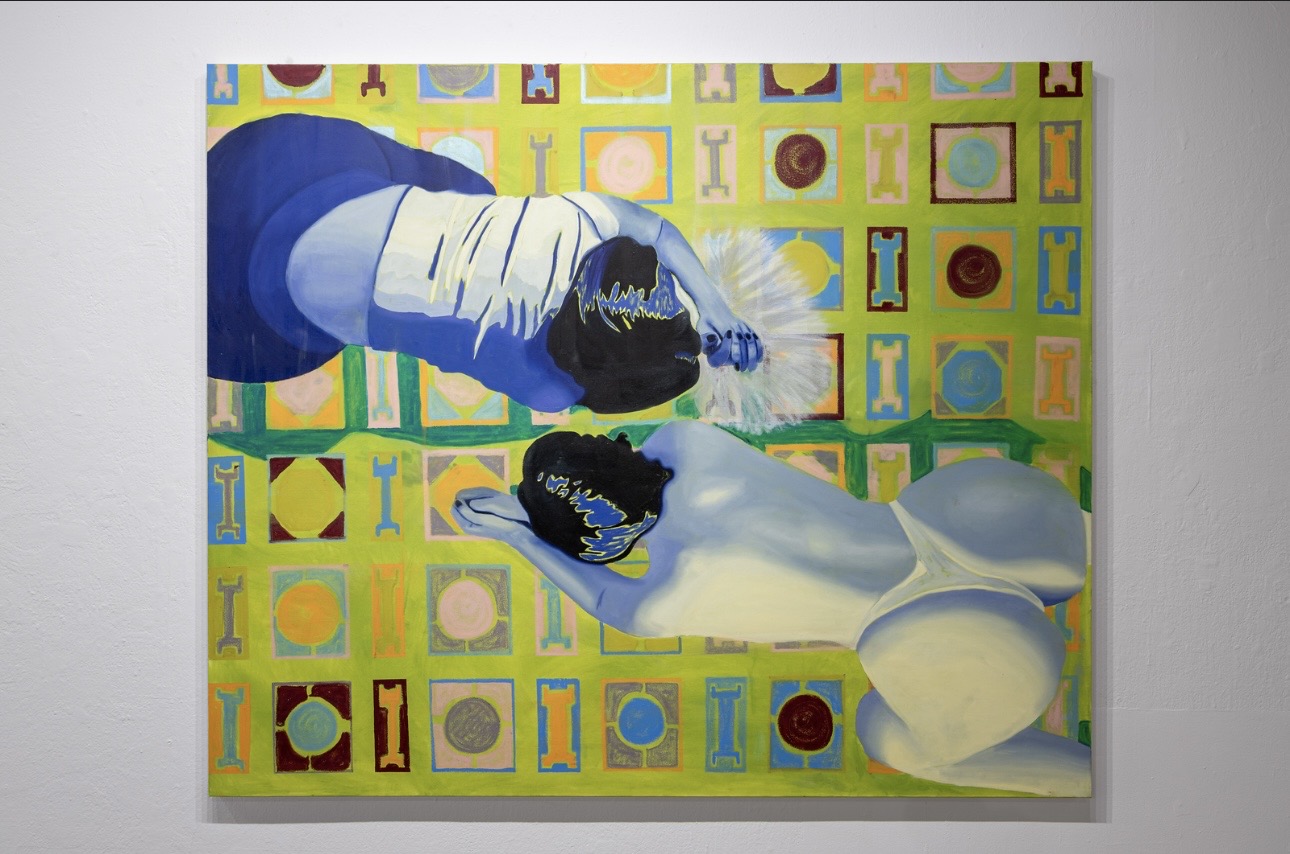 Person lying on a table with bowls, colorful patterned background, wearing a white shirt and dark pants.
