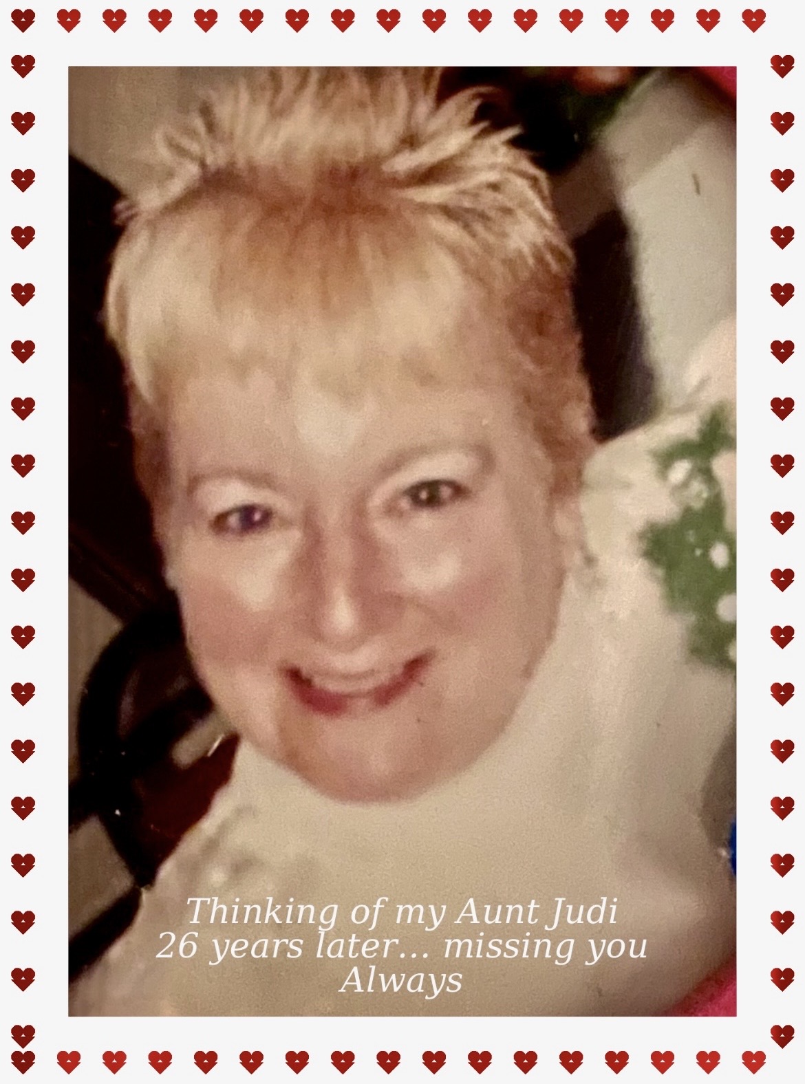 Smiling woman with short, light-colored hair, surrounded by a heart border, with text about Aunt Judi's 26th anniversary.