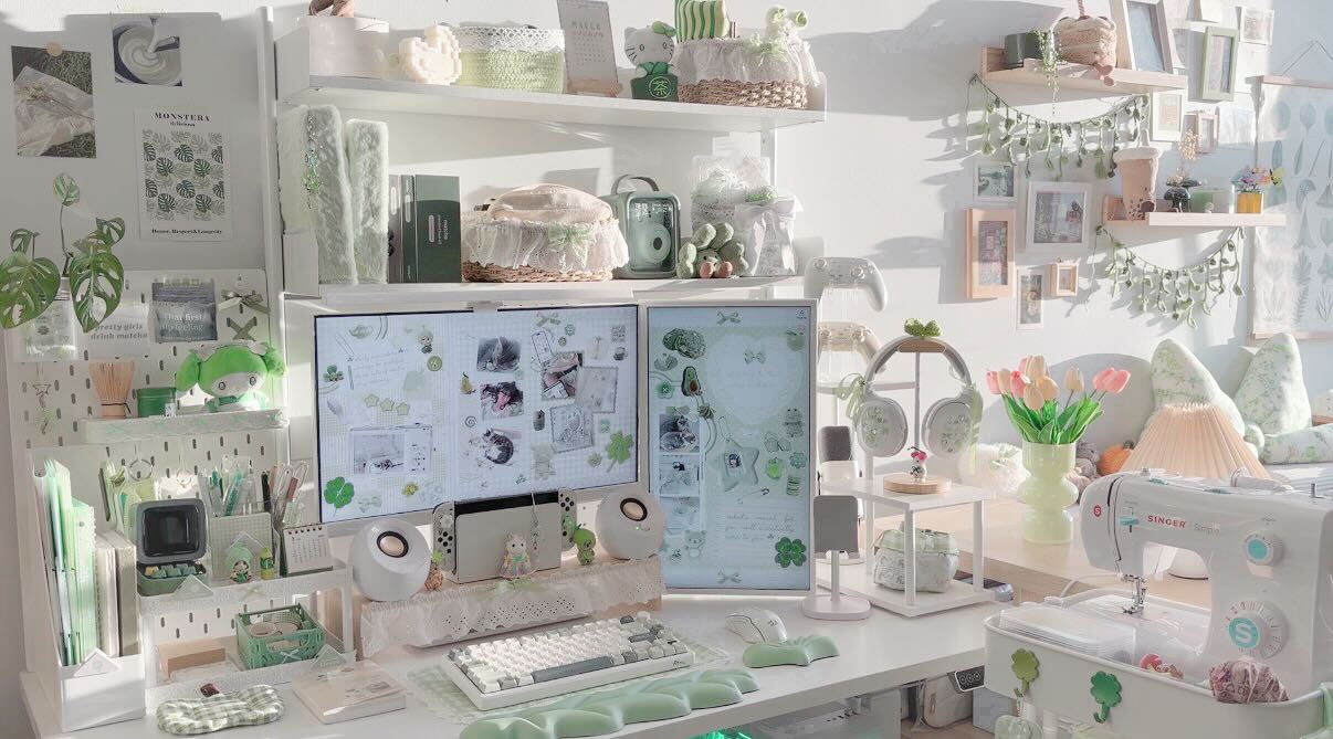 A workspace with two computer monitors, shelves with plants, books, and decorative items, and a white desk with various objects.