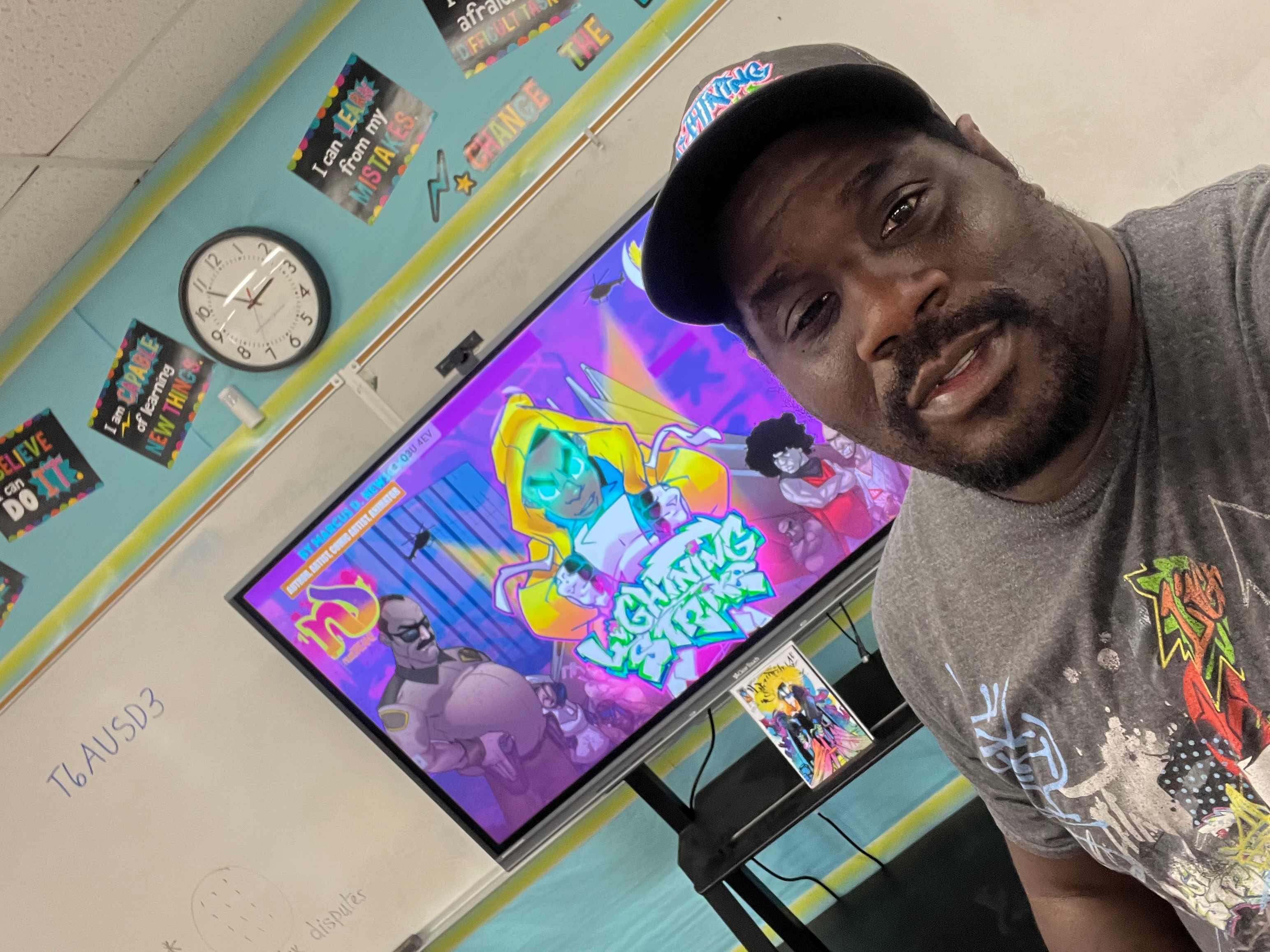 Man taking selfie in classroom with colorful screen and clock on wall.