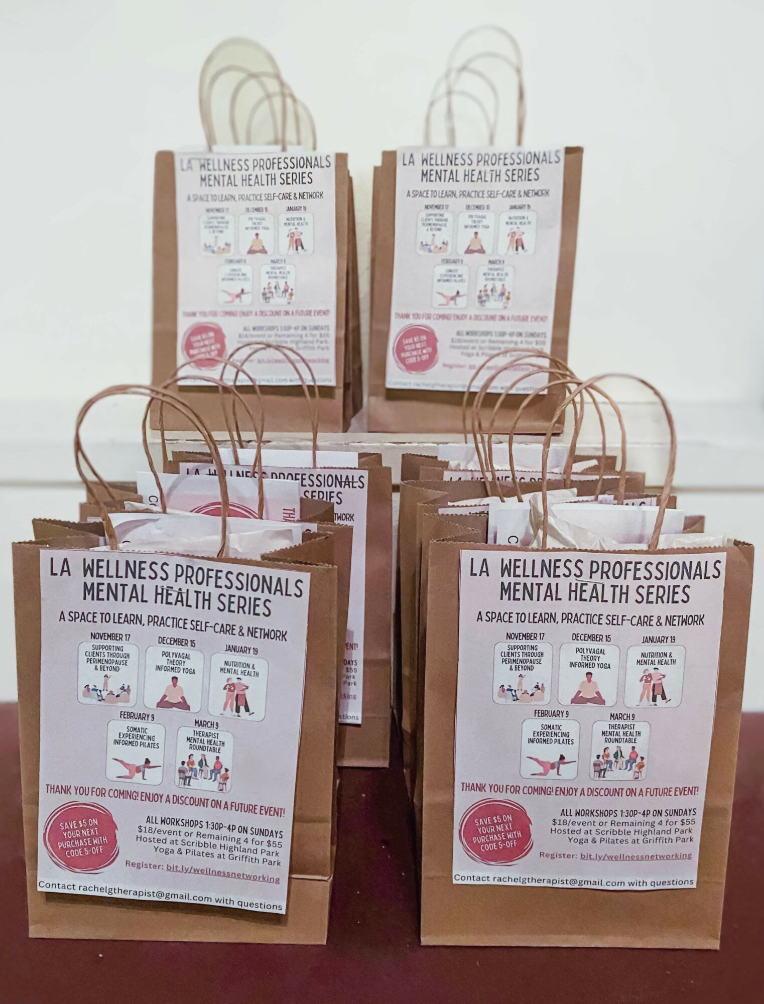 Four paper bags with handles, each containing a flyer for mental health series, arranged on a surface against a plain background.